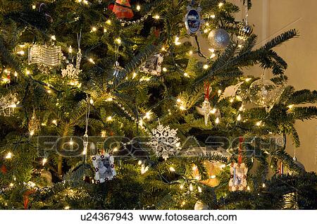 Stock Image - Extreme close-up of lit Christmas tree with decoration ornaments. Fotosearch
