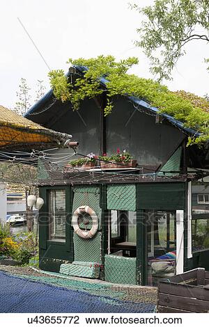 Stock Image - Facade of cottage covered in commercial fishing net. Fotosearch