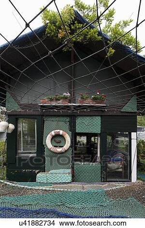Facade of residential structure covered in commercial fishing net View Large Photo Image Picture - Facade of residential structure covered in commercial fishing net. Fotosearch