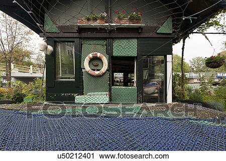 Stock Image - Facade of residential structure covered in fishing net. Fotosearch