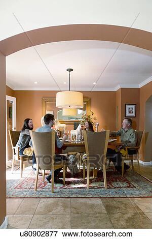 Stock Photo - Family around dining table in contemporary home, Albuquerque, New Mexico, USA. Fotosearch