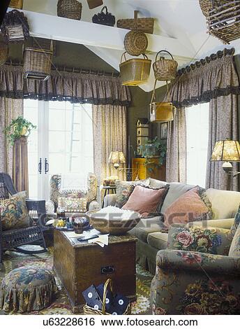 FAMILY ROOM: Cozy, floral. Olive/rose/brown drapes, furniture, valance and curtains, French doors, baskets, wood bowl popcorn, Ralph Lauren style fabrics, wood trunk, wicker chair View Large Photo Image Stock Photograph - FAMILY ROOM: Cozy, floral. Olive/rose/brown drapes, furniture, valance and curtains, French doors, baskets, wood bowl popcorn, Ralph Lauren style fabrics, wood trunk, wicker chair. Fotosearch