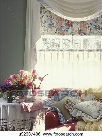 Stock Images Of Family Rooms Detail Round End Table Covered With And Linen Tablecloth Flowers Raspberry Colored Sofa Covered With Pillows Yellow Throw White Swag Valance Fl Shade Ring Top Cafe Curtains