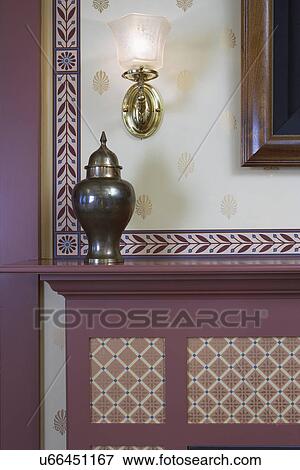 Stock Photo - FIREPLACE DETAILS: Basement library, Victorian wallpaper inset panels on fireplace, inset border, brass urn, antique wall sconce. Fotosearch