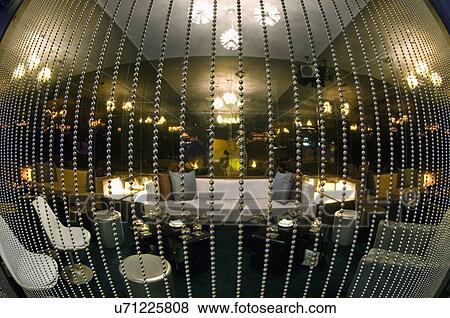 Stock Photo - Fisheye view of lounge area behind beaded curtain in nightclub. Fotosearch