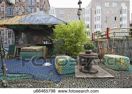 Stock Photo - Fishing net Ottoman with coffee table in front of house. Fotosearch