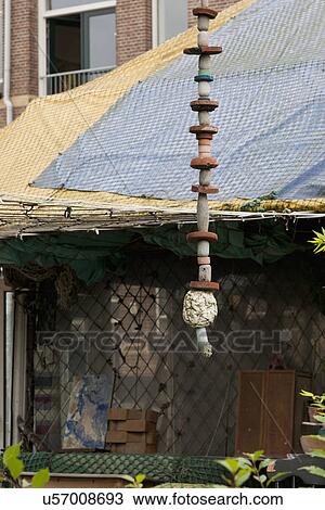 Stock Image - Floats hanging in front of cottage covered in fishing nets. Fotosearch