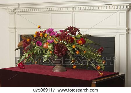 Stock Photo - FLORAL ARRANGEMENTS: Tall pink Oriental lily in a glass vas sit on hall table in front of painted blue paneled door, sidelight to left, Floral Designer: Pillar Simon. Fotosearch