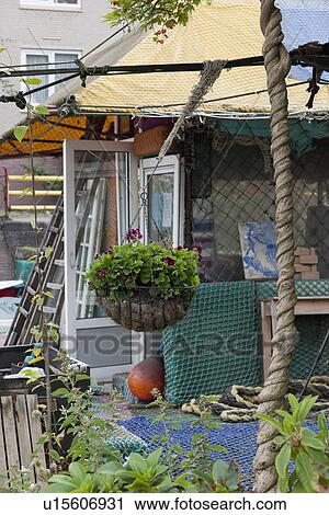 Stock Image - Flower basket hanging outside cottage. Fotosearch
