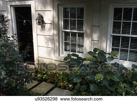 FRONT DOORS: City living, cut limestone, outdoor lanterns, begonia and hydrangea, two windows showing View Large Photo Image Stock Photo - FRONT DOORS: City living, cut limestone, outdoor lanterns, begonia and hydrangea, two windows showing. Fotosearch
