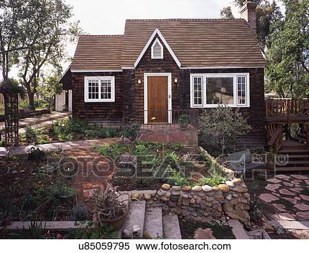Stock Photography - Front exterior wooden Cape Cod cottage and landscaping; San Diego; California; USA. Fotosearch