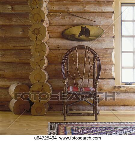 FURNITURE DETAILS: Rustic twig chair in center with tiny red cushion. Above tiny semi-oval painting of grizzly bear. View Large Photo Image Picture - FURNITURE DETAILS: Rustic twig chair in center with tiny red cushion. Above tiny semi-oval painting of grizzly bear. . Fotosearch