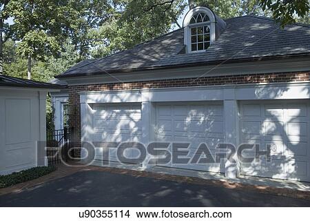 GARAGE: Classical styled detached red brick, three car, Palladian window on roof, blacktop driveway edged with brick, horizontal angle view, View Large Photo Image Picture - GARAGE: Classical styled detached red brick, three car, Palladian window on roof, blacktop driveway edged with brick, horizontal angle view,. Fotosearch
