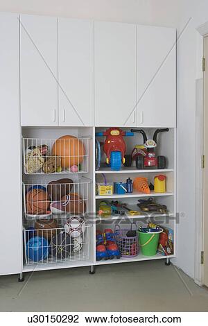 Garage Storage Clean And Organized After Pictures Storage Cabinet Detail Wire Pull Out Bins Filled With Balls Open Doors On Cabinet To Reveal Toys Stock Image U30150292 Fotosearch