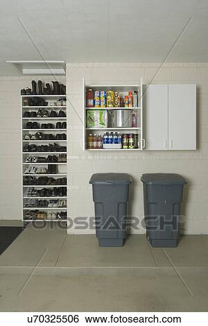 Garage Storage Clean Storage Shelves And Cabinets Two Garbage Cans Under Open Cabinet Doors Shoe Rack To Left Stock Photograph U70325506 Fotosearch