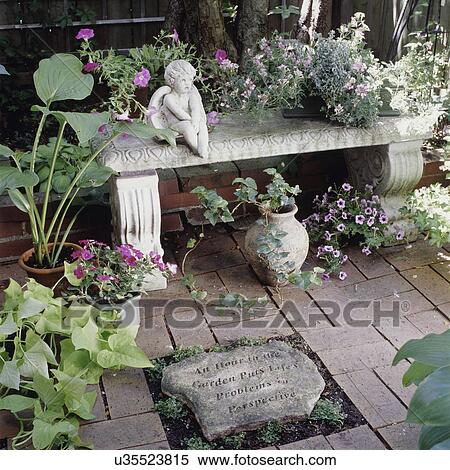 Garden with carved stone surrounded by pos of blooming flowers such as petunias and begonias, stone angle View Large Photo Image Stock Photography - Garden with carved stone surrounded by pos of blooming flowers such as petunias and begonias, stone angle. Fotosearch