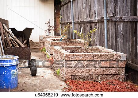 Gardening equipments and wheelbarrow by flower box View Large Photo Image Stock Photo - Gardening equipments and wheelbarrow by flower box. Fotosearch