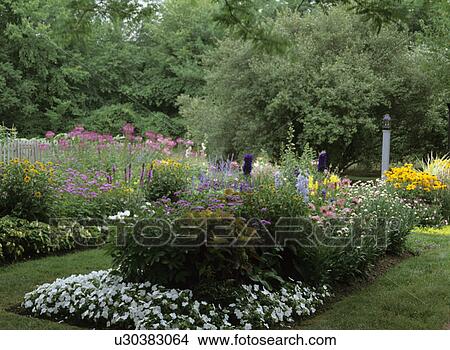 Gardens: full blooming flower beds lantern on a post, fenced along one side, colorful wild garden View Large Photo Image Picture - Gardens: full blooming flower beds lantern on a post, fenced along one side, colorful wild garden. Fotosearch