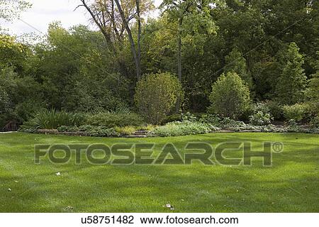 GARDENS: Lawn, corner flower bed with rock edging, perennials View Large Photo Image Stock Image - GARDENS: Lawn, corner flower bed with rock edging, perennials. Fotosearch