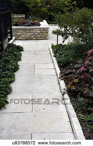 Stock Image - GARDENS: limestone walkway and edging, perennials,. Fotosearch
