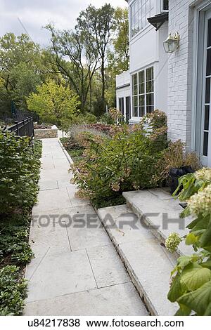 Stock Photo - GARDENS: limestone walkway and steps to home, brass lighting, hydrangea. Fotosearch