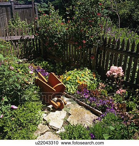 GARDENS: weathered picket fence surrounds a cutting garden of flowers, herbs, small orange child's wheelbarrow on flagstone path, pink honeysuckle View Large Photo Image Stock Image - GARDENS: weathered picket fence surrounds a cutting garden of flowers, herbs, small orange child's wheelbarrow on flagstone path, pink honeysuckle. Fotosearch