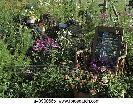 Gardens: Whimsical garden of household items, wicker chair, stained glass window, potted plants at foot of chair, rusting bike. View Large Photo Image Stock Photography - Gardens: Whimsical garden of household items, wicker chair, stained glass window, potted plants at foot of chair, rusting bike.. Fotosearch