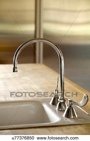 Stock Image - Gooseneck faucet with running water; Carpinteria; California; USA. Fotosearch