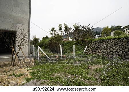 Grass and stone wall along new home under construction View Large Photo Image Picture - Grass and stone wall along new home under construction. Fotosearch
