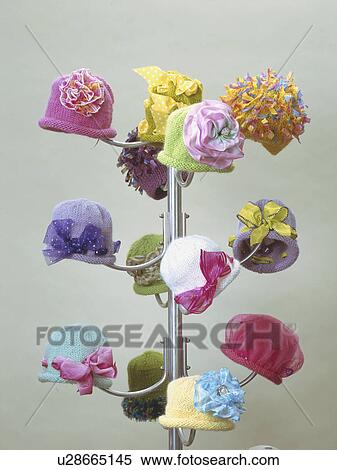 Handknit baby hats adorned with ribbons on displayed on hat rack View Large Photo Image Stock Photography - Handknit baby hats adorned with ribbons on displayed on hat rack. Fotosearch