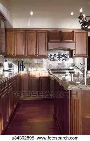 Stock Photography - Hardwood floors and wooden cabinets in traditional kitchen, Laguna Beach, California, USA. Fotosearch