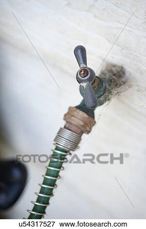 High angle view of a gardening hose attached to faucet View Large Photo Image Stock Photo - High angle view of a gardening hose attached to faucet. Fotosearch