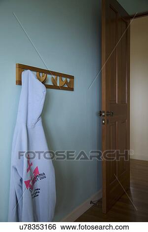 Stock Photograph - Hooded sweatshirt hanging on hook in blue bedroom; Carpinteria; California; USA. Fotosearch
