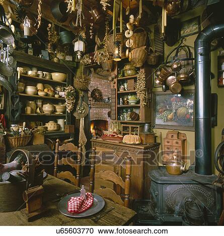Stock Image - Interior of a country kitchen with old utensils hanging from ceiling. Fotosearch