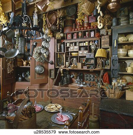 Interior of a country kitchen with old utensils hanging from ceiling View Large Photo Image Stock Photo - Interior of a country kitchen with old utensils hanging from ceiling. Fotosearch