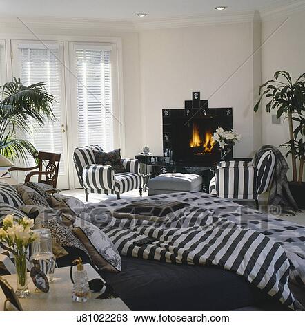 Stock Image - Interior of a modern bedroom with fireplace and French doors. Fotosearch