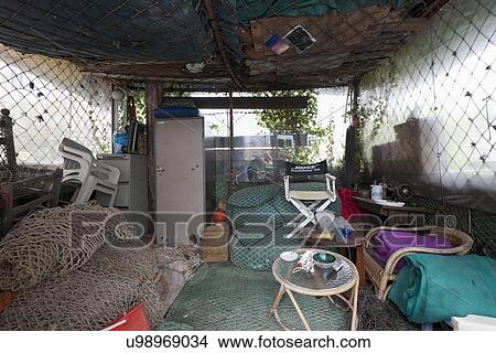 Picture - Interior of cottage covered with commercial fishing nets. Fotosearch