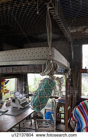 Picture - Interior of cottage with objects covered in fishing nets. Fotosearch