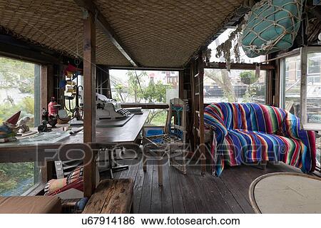 Stock Photograph - Interior of cottage with sofa and old-fashioned typewriter on table. Fotosearch