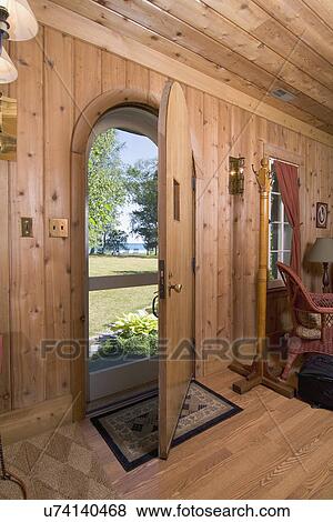 Stock Photo - Interior view of front door looking outside in cabin style home; Charlevoix; Missouri; USA. Fotosearch