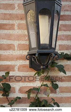 Stock Photo - Italianate lantern style sconce on brick wall; Irvine; California; USA. Fotosearch