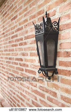 Stock Photo - Italianate lantern style sconce on brick wall; Irvine; California; USA. Fotosearch