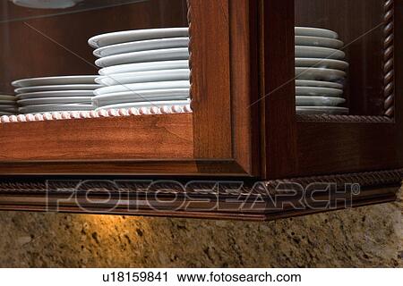 KITCHEN: close up of edge of glass kitchen cabinet, rope molding, white plates stacked, glass is on front and sides of cabinet View Large Photo Image Stock Image - KITCHEN: close up of edge of glass kitchen cabinet, rope molding, white plates stacked, glass is on front and sides of cabinet. Fotosearch
