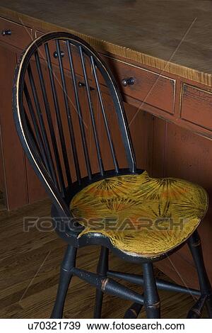 KITCHEN DETAILS: Close up of reproduction Windsor style chair barstool, seat has been painted to reproduce a pattern seen on an antique trunk. View Large Photo Image Stock Photo - KITCHEN DETAILS: Close up of reproduction Windsor style chair barstool, seat has been painted to reproduce a pattern seen on an antique trunk.. Fotosearch