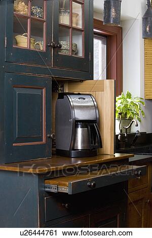 KITCHEN DETAILS: Custom furniture style cabinets by David Smith, open door reveals coffee maker and pull out work space, distressed dark green finish View Large Photo Image Stock Image - KITCHEN DETAILS: Custom furniture style cabinets by David Smith, open door reveals coffee maker and pull out work space, distressed dark green finish. Fotosearch