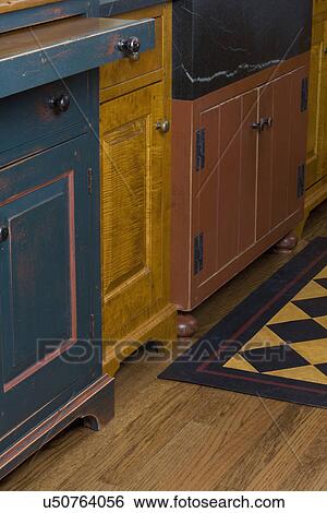 KITCHEN DETAILS: Furniture style cabinets by David Smith, detail of bun feet and bracket feet, different paint and stain finishes on each cabinet, floor cloth wood floor. View Large Photo Image Stock Photograph - KITCHEN DETAILS: Furniture style cabinets by David Smith, detail of bun feet and bracket feet, different paint and stain finishes on each cabinet, floor cloth wood floor.. Fotosearch