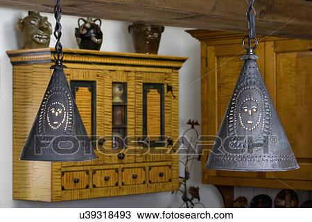 KITCHEN DETAILS: Punched tin pendant light fixtures done by tinsmith Michael P. Terragna, grain painted custom cabinets by David Smith in background. View Large Photo Image Stock Image - KITCHEN DETAILS: Punched tin pendant light fixtures done by tinsmith Michael P. Terragna, grain painted custom cabinets by David Smith in background.. Fotosearch