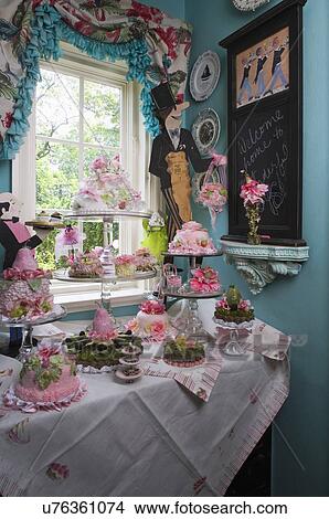 Picture - KITCHEN PANTRY: Butler theme with hand made silk pastries, cakes and tarts on glass cake stands, vintage linens on cabinet and on window chalkboard,. Fotosearch