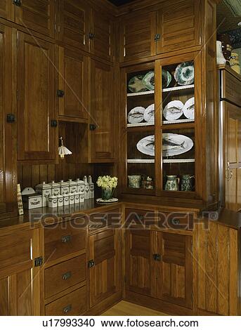 KITCHEN PANTRY with warm glow of wood cabinets and drawers of 1880's collection of FISH plates & platters, cannister set View Large Photo Image Stock Image - KITCHEN PANTRY with warm glow of wood cabinets and drawers of 1880's collection of FISH plates & platters, cannister set. Fotosearch