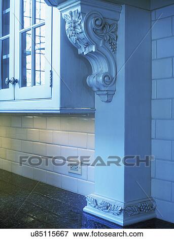 KITCHENS - Architectural detail added as embellishment, carved corbel supports exhaust hood. White classic Euro look, subway tile, granite counter, close up detail View Large Photo Image Stock Photo - KITCHENS - Architectural detail added as embellishment, carved corbel supports exhaust hood. White classic Euro look, subway tile, granite counter, close up detail. Fotosearch